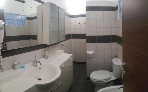 a bathroom with a sink and a toilet and a mirror at SERRA E MESU Affittacamere in Magomadas
