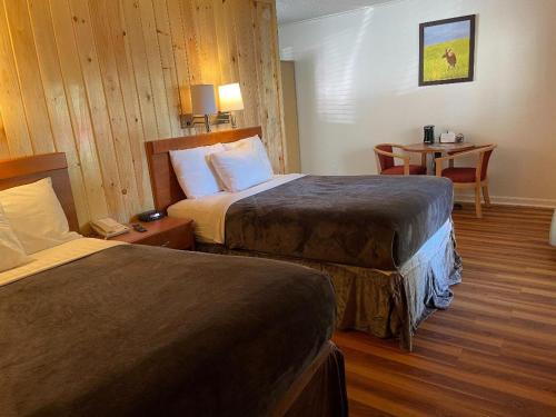 um quarto de hotel com duas camas e uma mesa em Zoders Inn and Suites em Gatlinburg