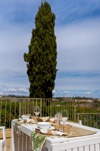 a white table with glasses and plates on it at Acqua di Civita Beauty & Rooms in Bagnoregio