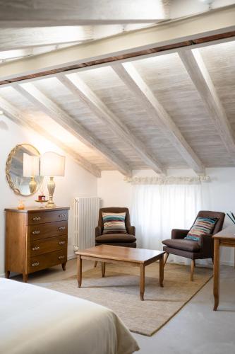 a bedroom with a bed and two chairs and a table at Acqua di Civita Beauty & Rooms in Bagnoregio