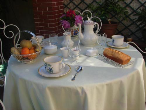 - une table avec un chiffon de table blanc, de la nourriture et des boissons dans l'établissement Le Cottage - Chambres d'hôtes Paris Saclay, à Bures-sur-Yvette