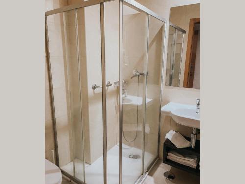 La salle de bains est pourvue d'une douche et d'un lavabo. dans l'établissement Hotel Coroa de Fátima, à Fátima