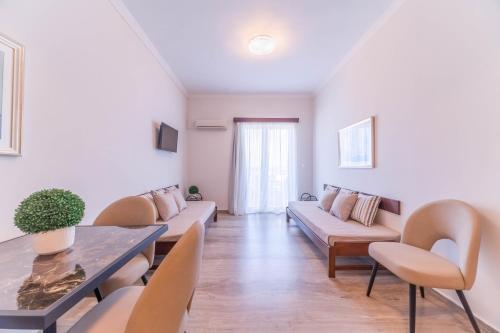 a living room with a couch and a table and chairs at Kalamaki Mare Suites in Kalamaki Chanion