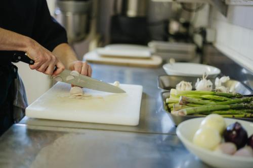 a person cutting up vegetables on a cutting board at Sure Hotel by Best Western Châteauroux in Le Poinçonnet