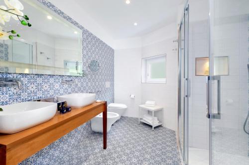 a bathroom with a tub and a sink and a toilet at Atlantic Palace Hotel in Sorrento