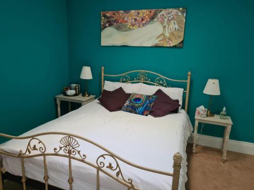 um quarto com uma cama branca e paredes azuis em Skellys em Ballymahon