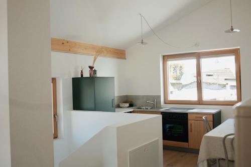 a white kitchen with a sink and a stove at Bergauf Appartement in Grossarl