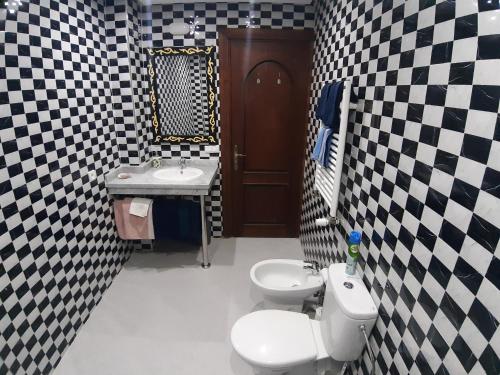 bagno con parete a scacchi in bianco e nero di Riad TANJIL a Casablanca