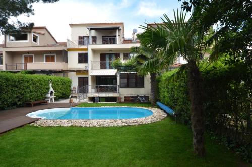 a house with a swimming pool in front of a yard at Apartments Villa Rossella 3 in Rovinj