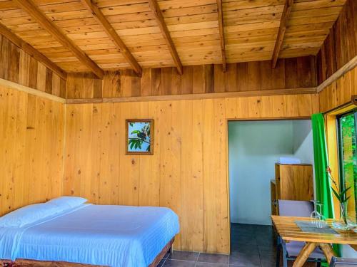 a bedroom with a bed in a wooden wall at Campo Verde B&B - Monteverde Costa Rica in Monteverde Costa Rica
