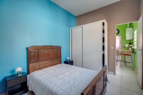 1 dormitorio con 1 cama grande y pared azul en Aquarelle en Arcachón