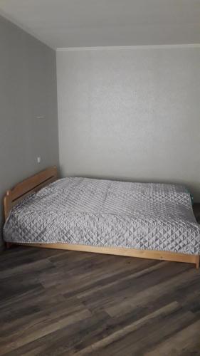 uma cama num quarto com uma moldura de madeira em Siguldas Street Apartment in Ventspils em Ventspils