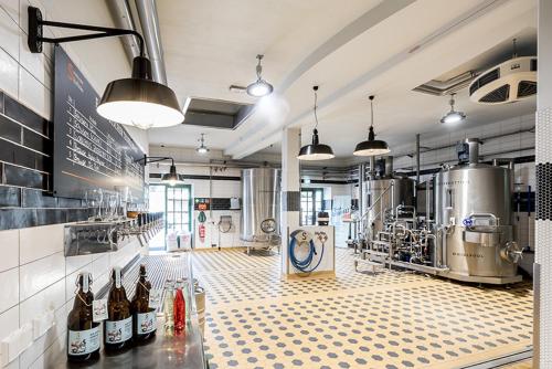 a large kitchen with bottles of wine on a counter at SCHULZENS Brauerei & Hotel in Tangermünde