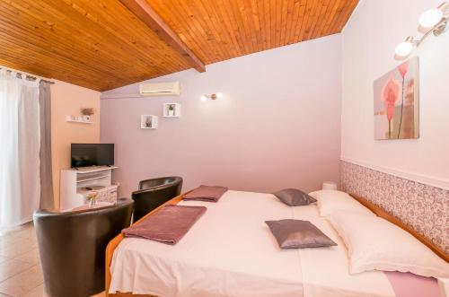 une chambre avec un lit et une télévision dans une chambre dans l'établissement Apartments and Room Zinka, à Vodice