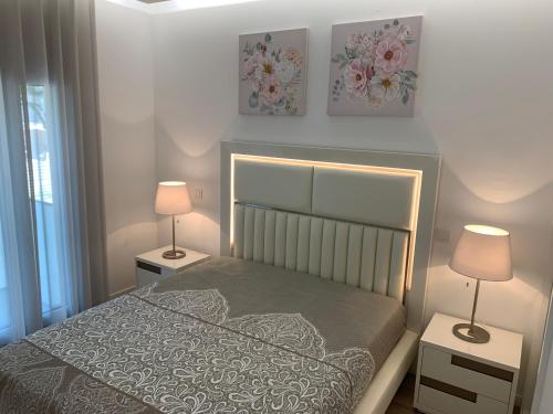 een slaapkamer met een bed met 2 lampen en 2 foto's bij Apartamentos Quebra-Mar 2 in Nazaré