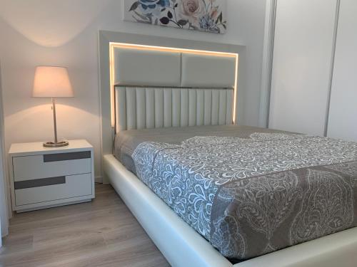 a bedroom with a bed and a lamp on a night stand at Apartamentos Quebra-Mar 2 in Nazaré