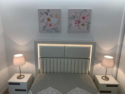 a bedroom with a bed and two lamps on tables at Apartamentos Quebra-Mar 2 in Nazaré