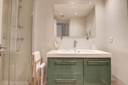 une salle de bain avec un lavabo, un miroir et une douche dans l'établissement Cozy Apartment, à Cannes