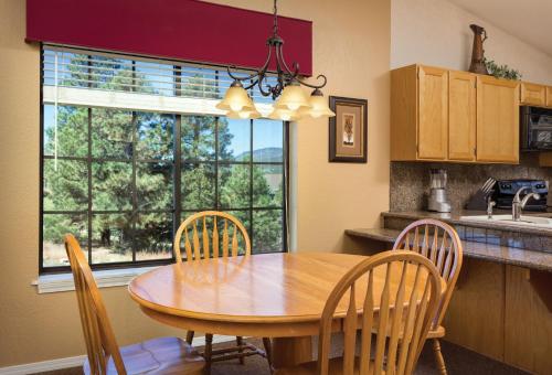 cocina con mesa de madera, sillas y ventana en Club Wyndham Flagstaff en Flagstaff