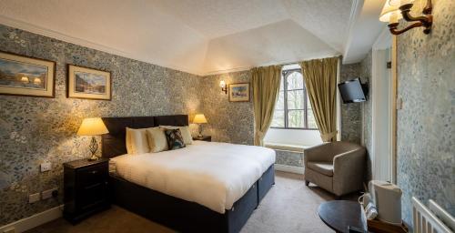 a bedroom with a bed and a chair in it at Badger Bar in Ambleside