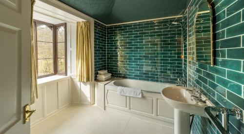 uma casa de banho com uma banheira e um lavatório em Badger Bar em Ambleside