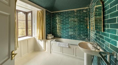 a bathroom with a tub and a sink at Badger Bar in Ambleside