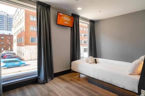 a bedroom with a bed and a large window at easyHotel Cardiff in Cardiff