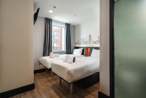 a hotel room with two beds and a window at easyHotel Cardiff in Cardiff