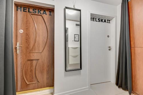 a bathroom with a wooden door and a mirror at Apartament w Dolnym Sopocie w przyziemiu by Grand Apartments in Sopot