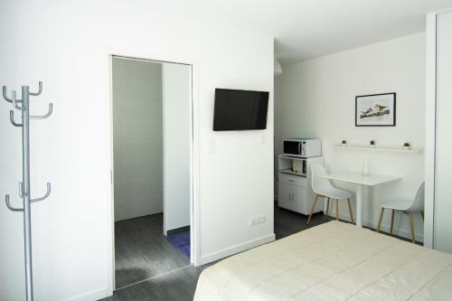 une chambre avec un lit, une table et un miroir dans l'établissement Studio indépendant chez l’habitant au calme (n°2), à Dompierre-sur-Yon