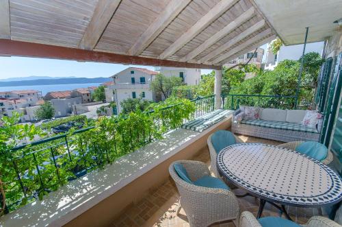 eine Terrasse mit Tisch und Stühlen auf einem Balkon in der Unterkunft Apartments Peric in Igrane