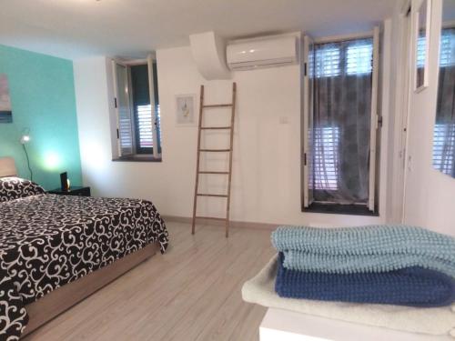 1 dormitorio con 1 cama, escalera y ventanas en Finisterrae, en Procida