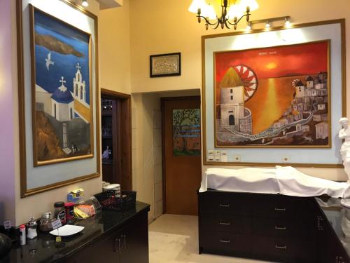 a bathroom with a dresser and a painting on the wall at Hotel Kosta Famissi in Kalabaka