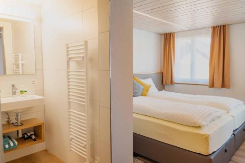 Dormitorio pequeño con cama y lavamanos en Gasthaus Engel Hasle en Hasle