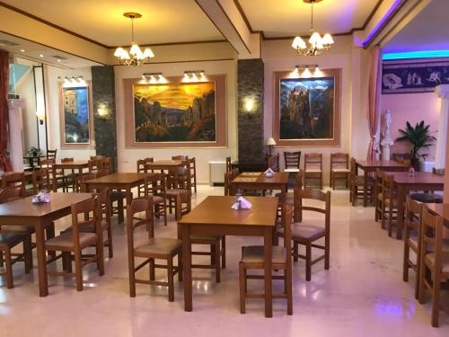 a dining room with wooden tables and chairs at Hotel Kosta Famissi in Kalabaka