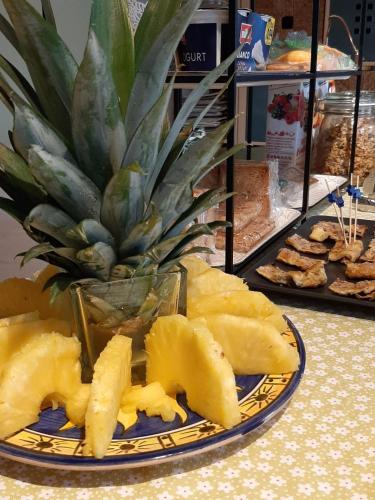 a plate of fruit on a table with a pineapple at cà bianca in Latisana