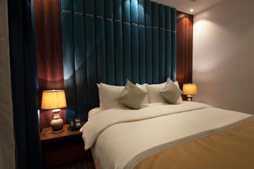 a bedroom with a large white bed with two lamps at Beach Time Villas Hotel in Jeddah