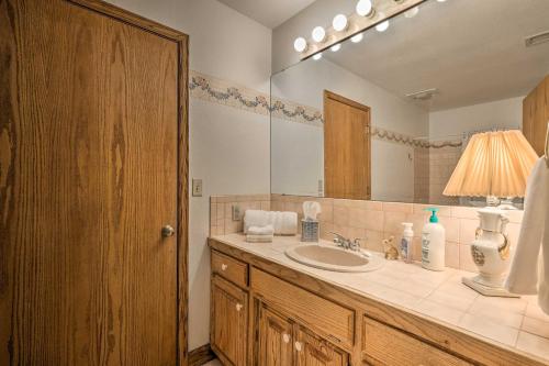 Un baño con lavabo y un espejo grande. en Pet-Friendly Home 7 Miles to Dickson Street!, en Fayetteville
