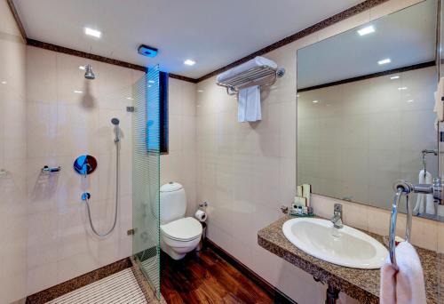 a bathroom with a sink and a shower and a toilet at Hotel Casa Fortuna in Kolkata