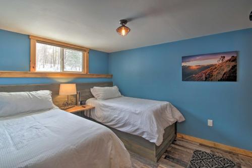sypialnia z 2 łóżkami i niebieską ścianą w obiekcie Cozy Condo Ski-In and Out with Burke Mountain Access! w mieście East Burke