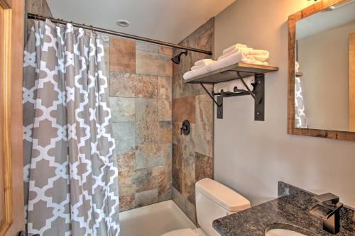 a bathroom with a shower and a toilet and a sink at Cozy Condo Ski-In and Out with Burke Mountain Access! in East Burke