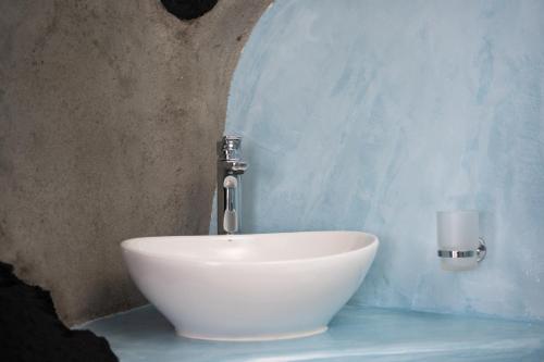 a bathroom with a white bowl sink with a faucet at Iatis View Collection in Imerovigli