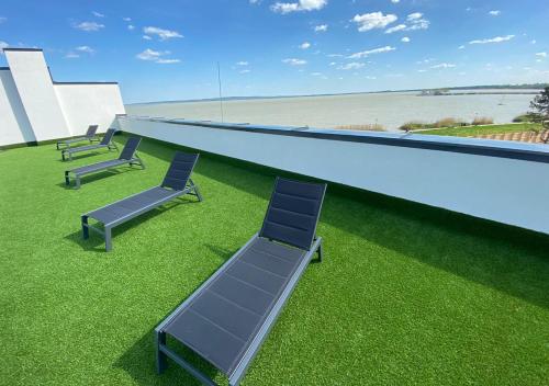 a row of chairs sitting on top of a building at Royal 27 apartman in Keszthely