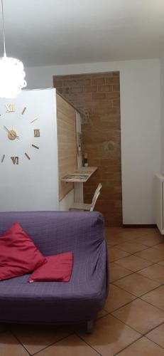 a room with a couch with a clock on the wall at Ascoli per te in Ascoli Piceno
