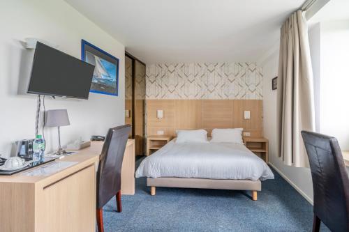 1 dormitorio con 1 cama y escritorio con ordenador en Cit Hotel LA PYRAMIDE, en Romorantin-Lanthenay