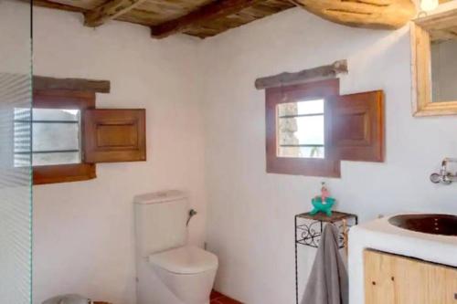 y baño con aseo y lavamanos. en CASA IBICENCA EN CALA D´HORT en San José