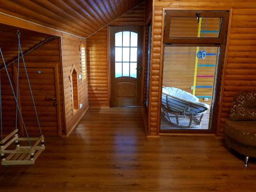pasillo de una cabaña de madera con puerta y escaleras en Вілла на Роші. Власна територія, мангал, альтанка., en Chernivtsi