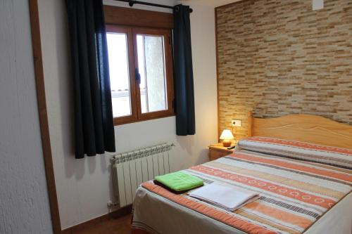 1 dormitorio con cama y ventana en Casa Rural Javier El Molino, en Las Majadas
