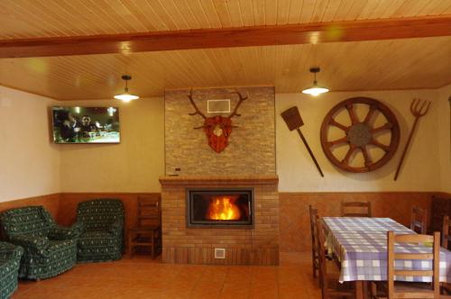 a living room with a fireplace and a table and chairs at Casa Rural Javier El Molino in Las Majadas