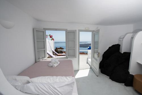 a bedroom with a bed and a view of the ocean at Iatis View Collection in Imerovigli